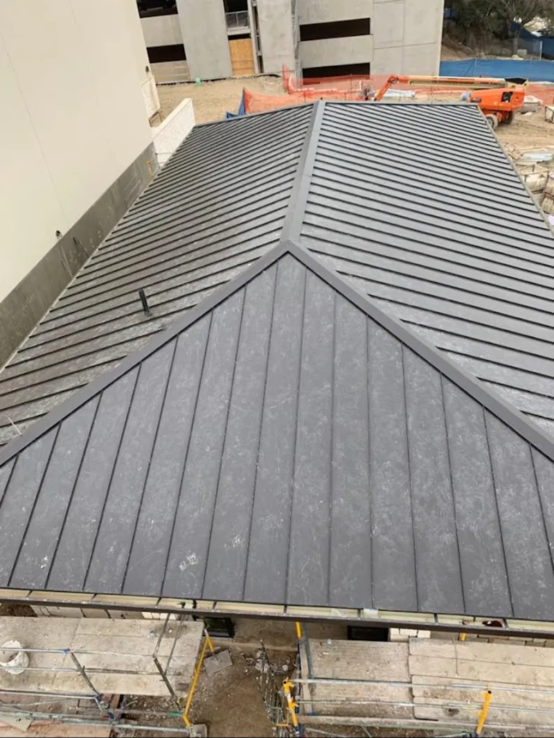 Commercial metal roof construction with crane equipment in Bothell East